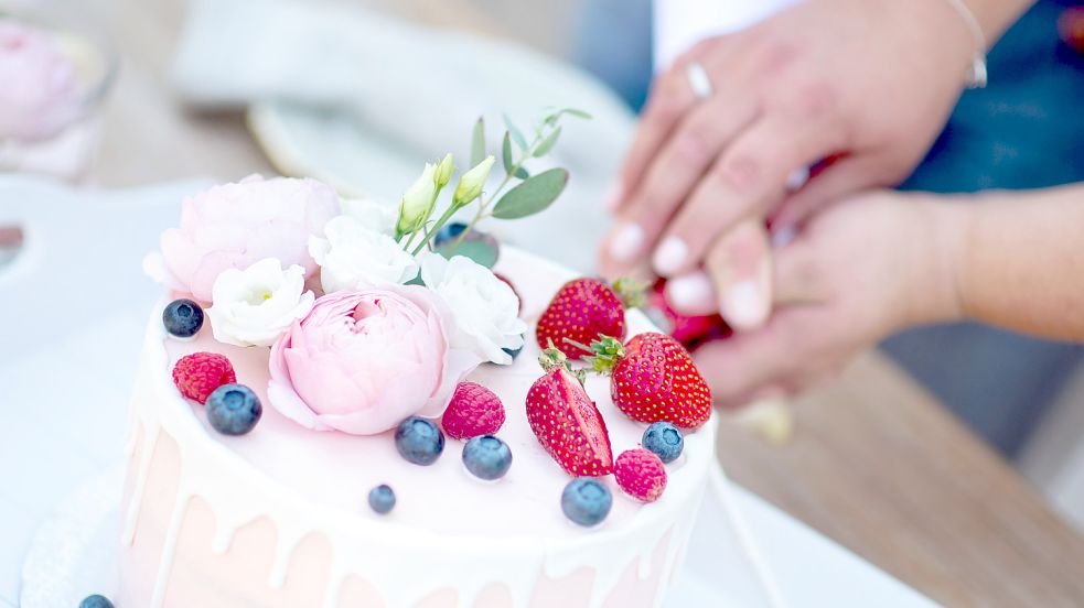 Ein Brautpaar schneidet eine Torte bei einer Hochzeitsfeier an. 2022 hat in Emden nur ein Paar mehr geheiratet als im Vorjahr. Foto: Dittrich/dpa