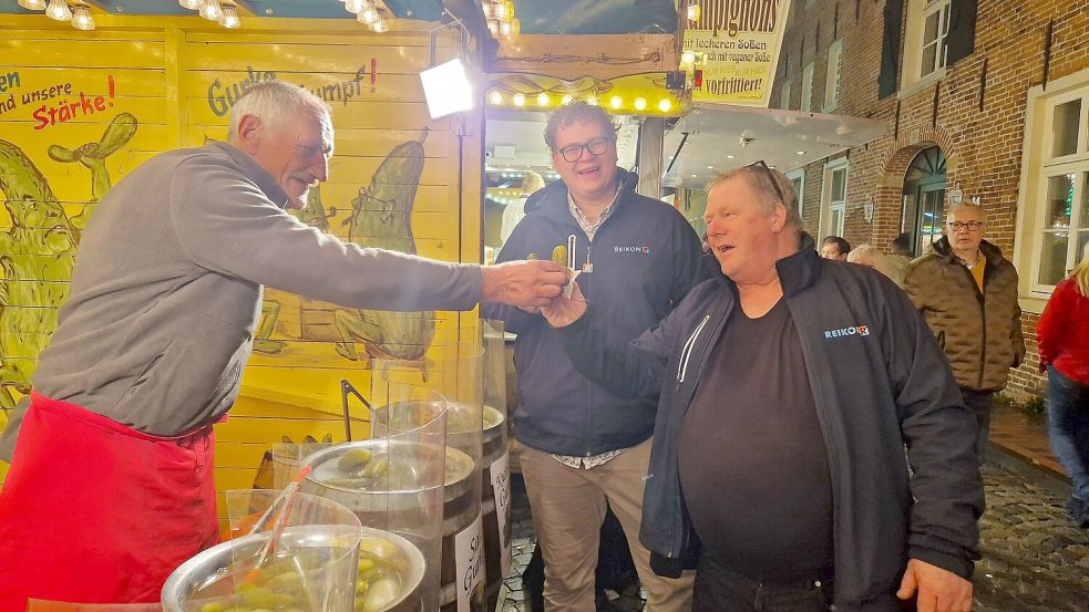 Detlef Dekarz (von links) reicht Jardo Zeemann (rechts) den Leckerbissen. Der Niederländer hat sich wie sein Kollege Johan Huismann für die klassische Gewürzgurke entschieden. Foto: Gettkowski