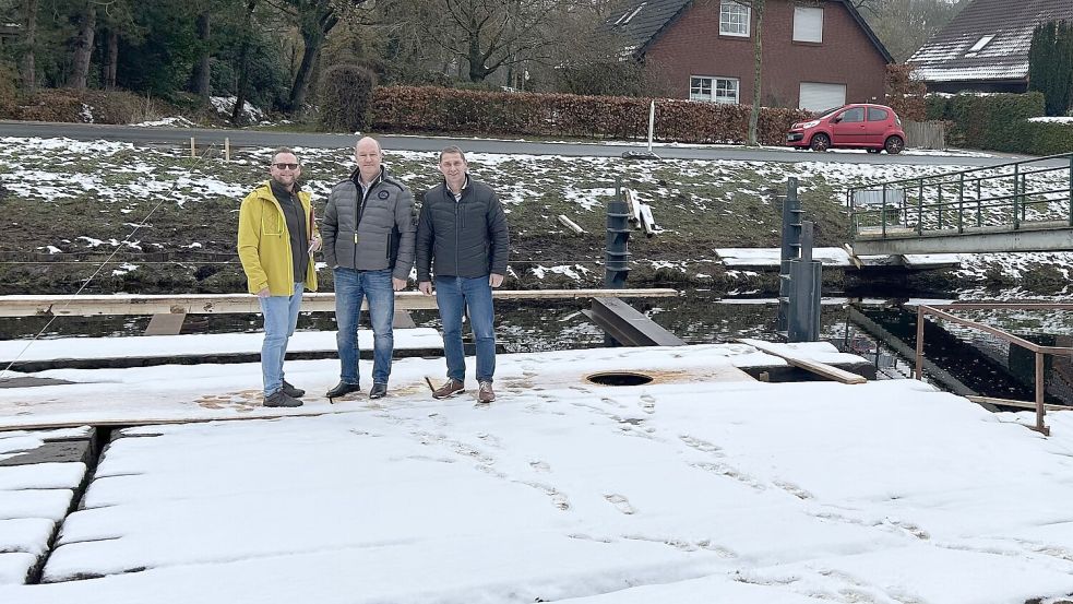 Die provisorischen Planken waren mit Schnee bedeckt. Torsten Stephan (Sachgebietsleiter Gemeindeentwicklung, von links), Bauleiter Rainer Wessels und der Uplengener Bürgermeister Heinz Trauernicht haben gezeigt, wie weit die neue Brücke in Uplengen ist. Foto: Heinig