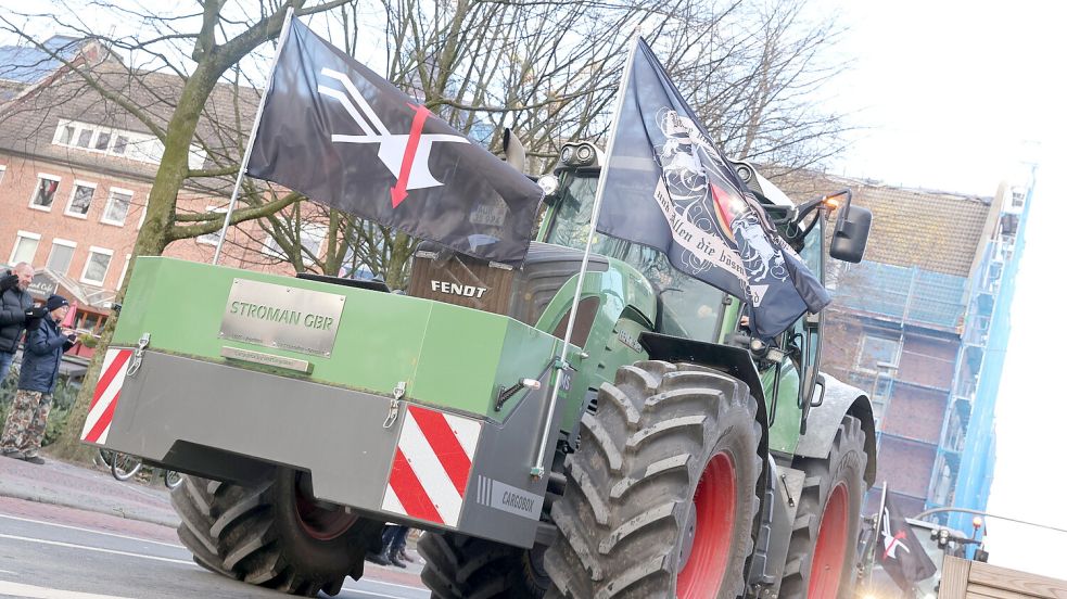 Die Landvolk-Bewegung-Fahne (links) wehte diese Woche nicht nur an diesem Trecker. Die schwarze Fahne war über Jahrzehnte die Protestfahne der ostfriesischen Bauern. Seit der Ursprung bekannt wurde, steht die Fahne in der Kritik. Foto: Hock