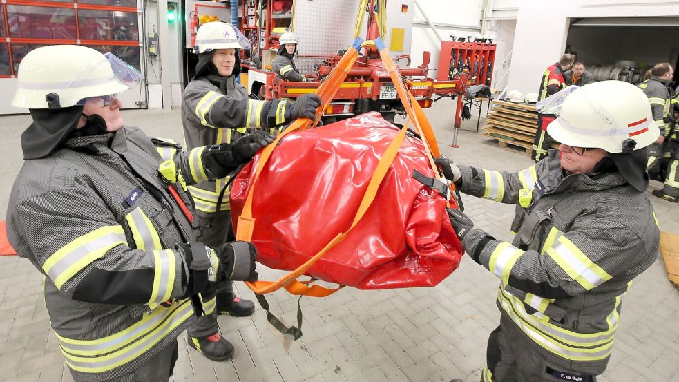 Frank de Buhr (rechts), Menno Pollmann (links) und Nico Schoon demonstrieren den Einsatz des Rettungsgeschirrs für Großtiere. Foto: Böning