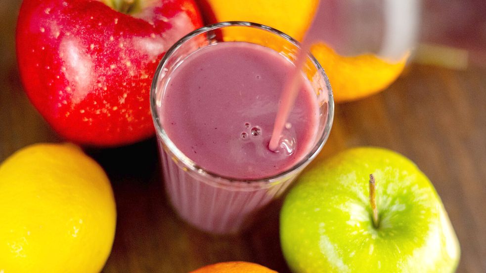 Früchte liegen um ein Glas mit einem Smoothie. Symbolfoto: Schuldt/DPA