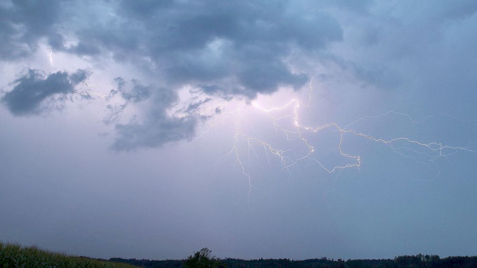 Ein Blitz zuckt bei einem Gewitter am abendlichen Himmel. Foto: Alexander Wolf/dpa