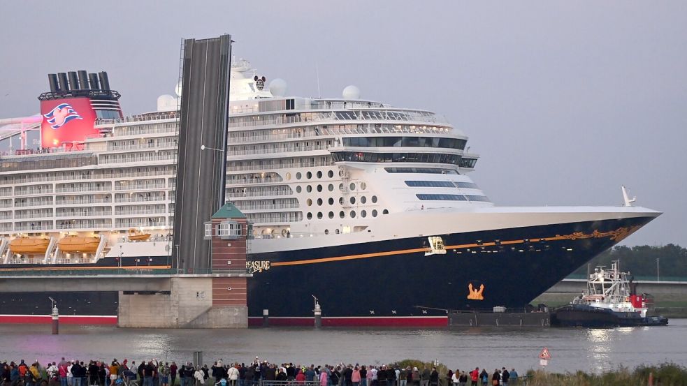 Die „Disney Treasure“ ist auf dem Weg über die Ems in Richtung Nordsee. Am Mittwochabend hat das Schiff die Jann-Berghaus-Brücke bei Leer passiert. Foto: Lohmann