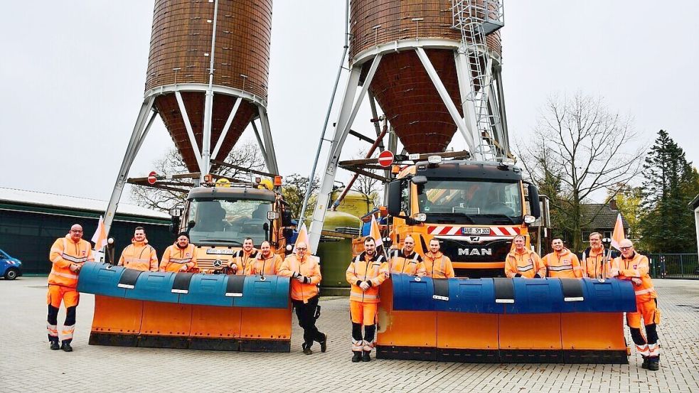 Sie sorgen auch im Winter für sichere Straßen: Ein Teil der insgesamt 25 Mitarbeitenden der Straßenmeisterei in Aurich. Hinter ihnen befinden sich zwei Silos, in denen das Streusalz gelagert wird. Foto: privat