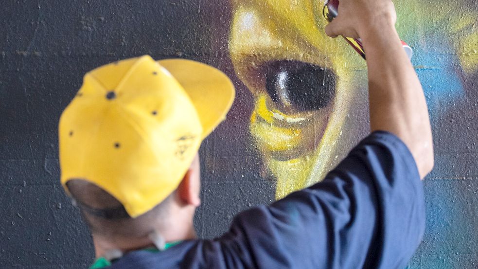 Ein Künstler entwirft ein Wandbild. In Leer will die Politik für künstlerische Graffiti wie auf diesem Symbolfoto mehr Platz schaffen. Symbolfoto: Hannes P. Albert/dpa