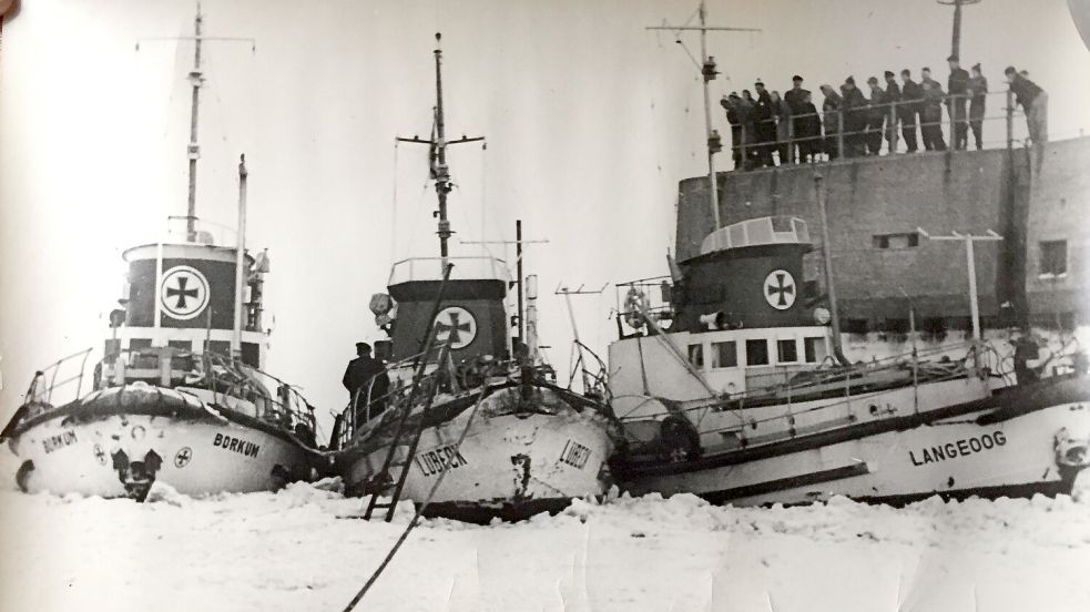 1948: Die „Borkum“, „Lübeck“ und „Langeoog“ halten die Verbindungen zu den Ostfriesischen Inseln notdürftig aufrecht. Am Molenkopf von Langeoog beäugen Inselbewohner die im Eis gefangenen Seenotrettungskreuzer der DGzRS. Bild: Sammlung Kruse