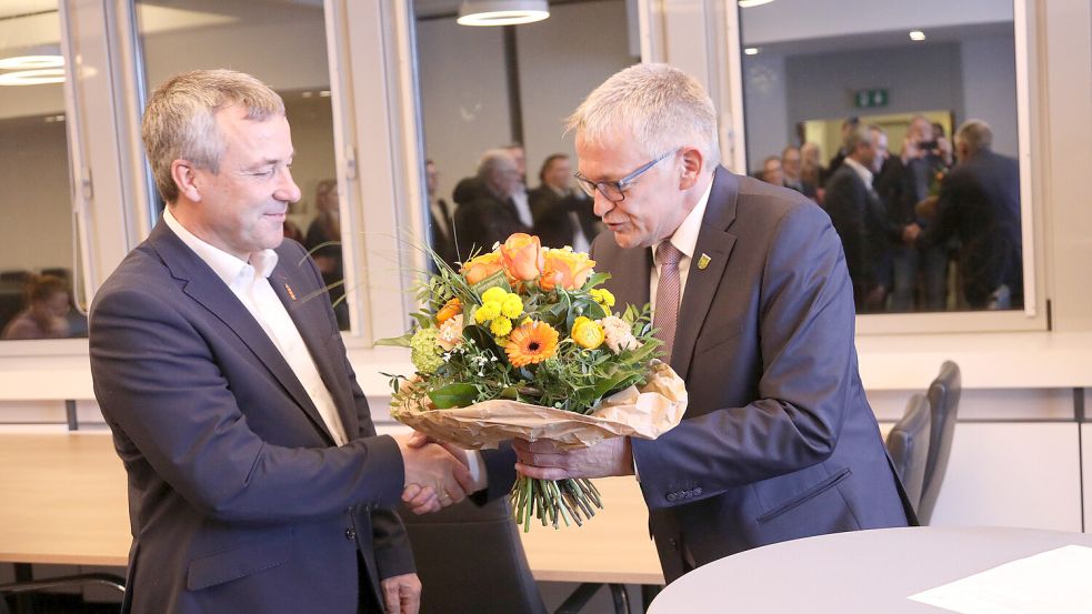 Johann Saathoff (SPD, links) hat erneut den Wahlkreis Aurich-Emden gewonnen. Wahlleiter Olaf Meinen gratuliert mit einem Blumenstrauß. Foto: Banik